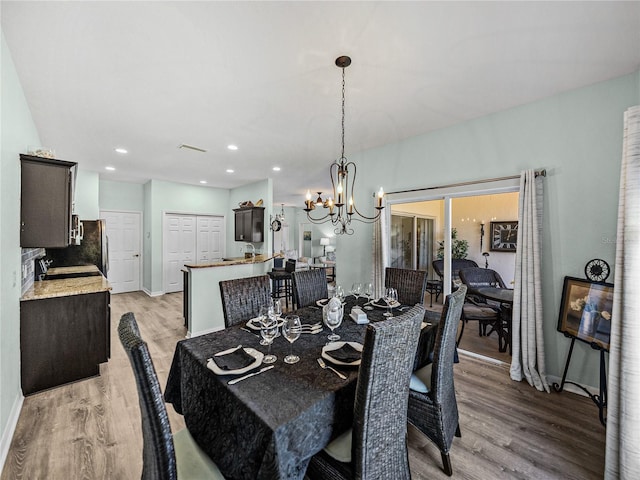 dining area with recessed lighting, an inviting chandelier, light wood-type flooring, baseboards, and visible vents