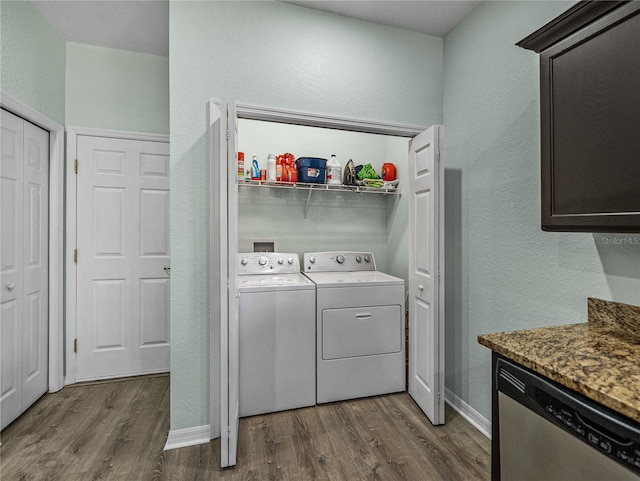 washroom with dark wood-style flooring, a textured wall, laundry area, and washer and clothes dryer