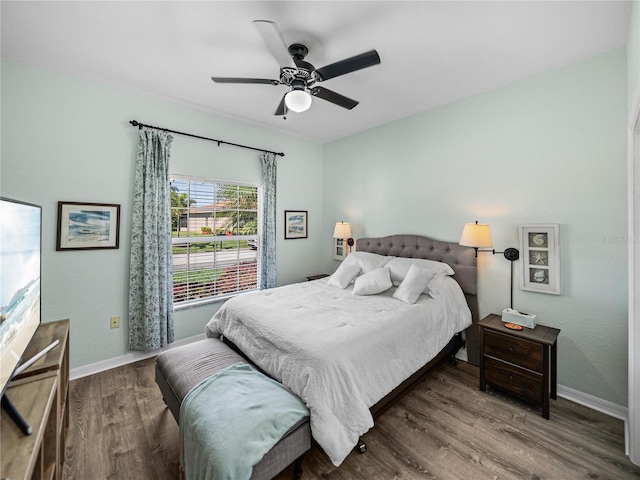 bedroom featuring baseboards, wood finished floors, and ceiling fan