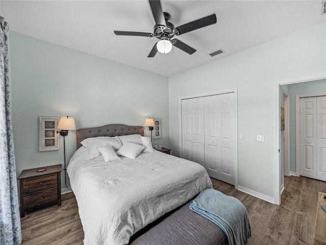 bedroom with a closet, baseboards, visible vents, and wood finished floors