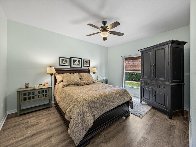 bedroom featuring baseboards, wood finished floors, and ceiling fan