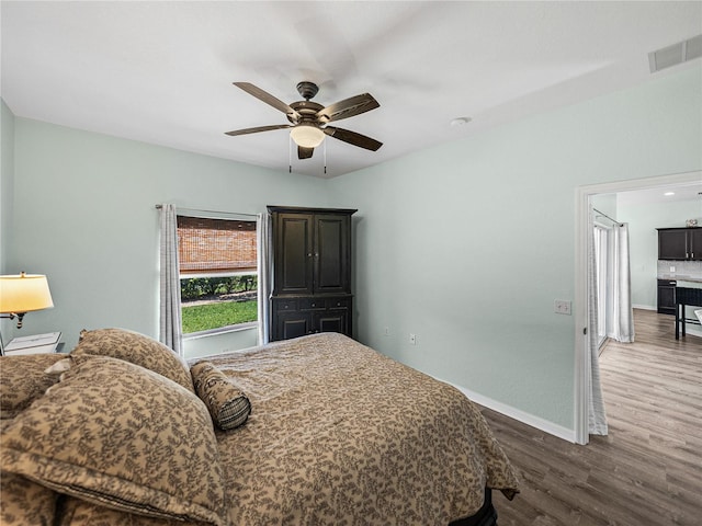 bedroom with dark wood finished floors, baseboards, visible vents, and a ceiling fan