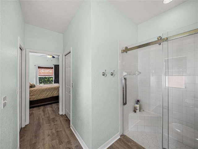 full bath featuring a stall shower, baseboards, wood finished floors, and ensuite bathroom