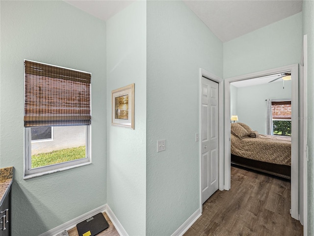 corridor with dark wood-style flooring and baseboards
