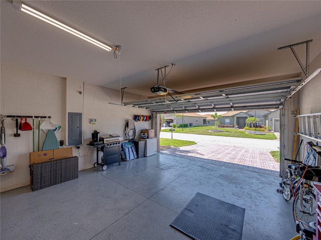garage with electric panel and concrete block wall