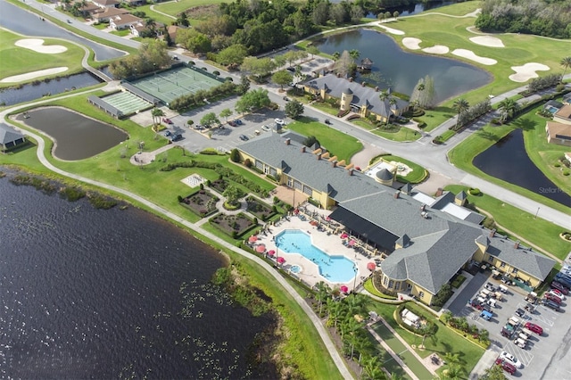 drone / aerial view featuring golf course view and a water view