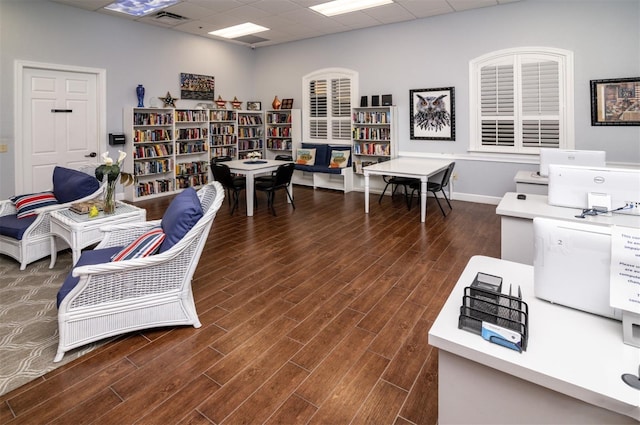 office space featuring baseboards, visible vents, wood finished floors, and a paneled ceiling