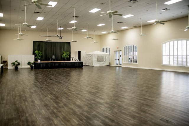 misc room with visible vents, a high ceiling, wood finished floors, and a ceiling fan