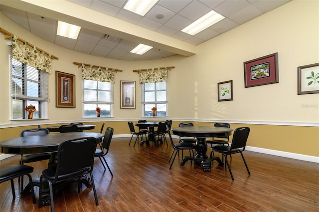 dining area with baseboards, dark wood-style flooring, visible vents, and a paneled ceiling
