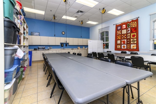 playroom featuring a drop ceiling, light tile patterned flooring, a sink, and visible vents