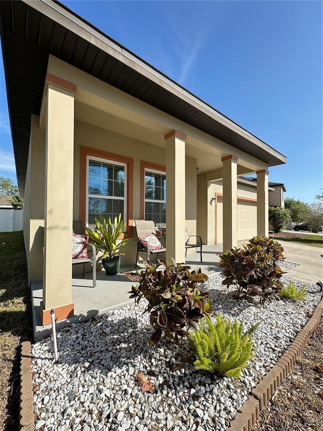 property entrance with a porch and stucco siding