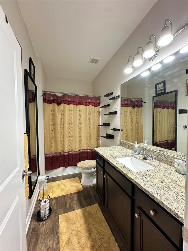 full bath with visible vents, toilet, wood finished floors, and vanity