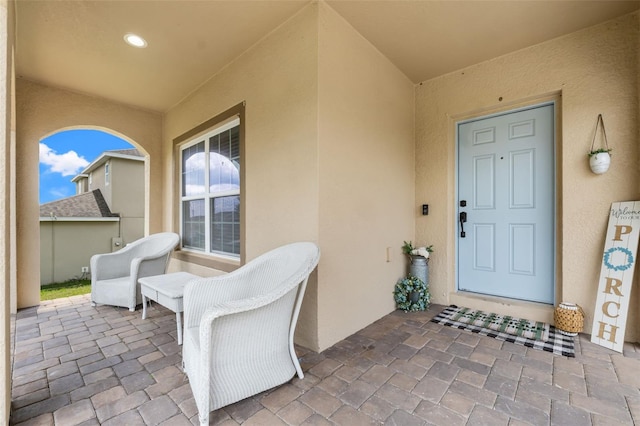 property entrance with stucco siding and a patio
