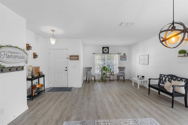 entryway with baseboards, visible vents, and light wood finished floors