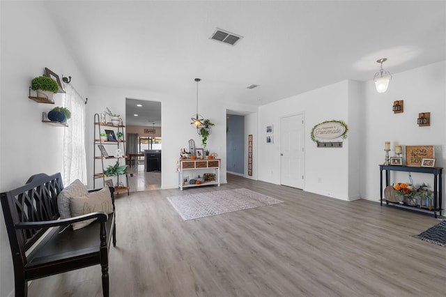 living area featuring wood finished floors, visible vents, and baseboards