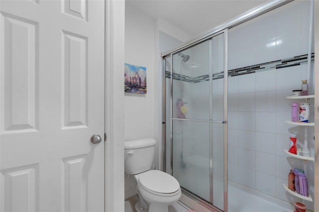 bathroom with a stall shower and toilet