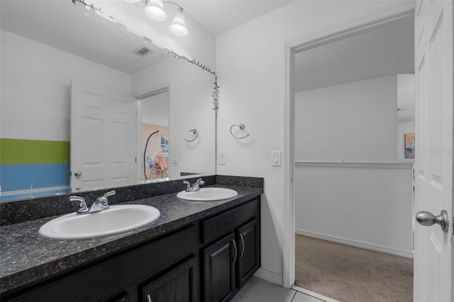 full bath featuring double vanity, baseboards, visible vents, and a sink