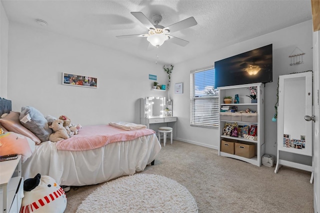 carpeted bedroom featuring baseboards, a textured ceiling, and a ceiling fan
