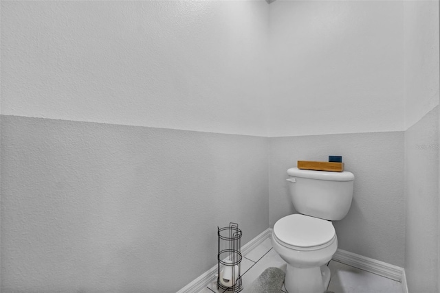 bathroom with toilet and baseboards