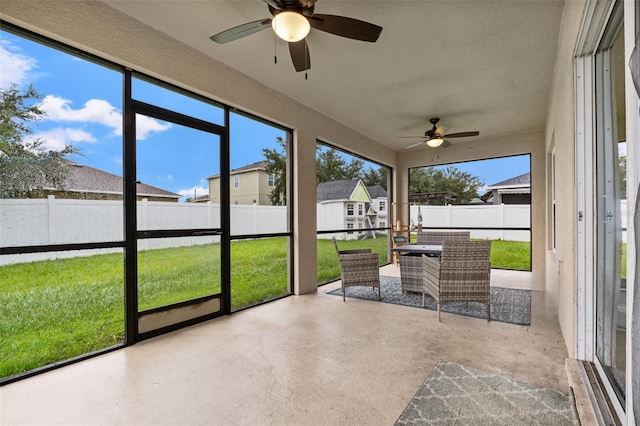 unfurnished sunroom with a wealth of natural light and ceiling fan