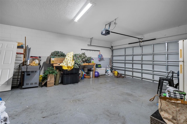 garage with a garage door opener and concrete block wall