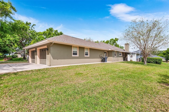 5020 Broadmore Dr, Auburndale, FL 33823 - back of property featuring stucco siding, driveway, a garage, and a lawn