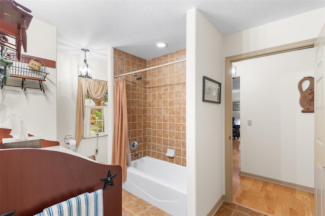 5020 Broadmore Dr, Auburndale, FL 33823 - full bathroom with shower / bath combo, tile patterned floors, a textured ceiling, baseboards, and a chandelier