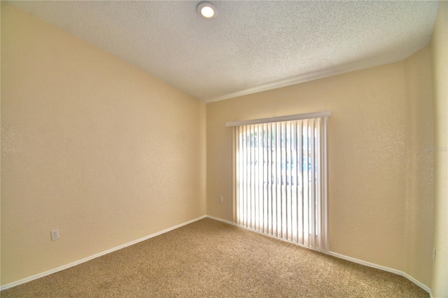 unfurnished room with carpet floors, baseboards, and a textured ceiling