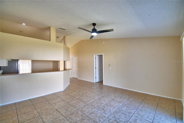 tiled spare room featuring a ceiling fan, a textured ceiling, lofted ceiling, baseboards, and visible vents