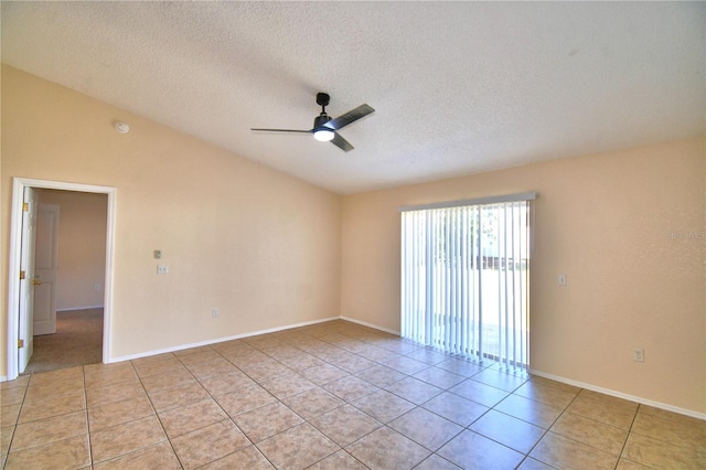 spare room with a ceiling fan, light tile patterned floors, lofted ceiling, and a textured ceiling
