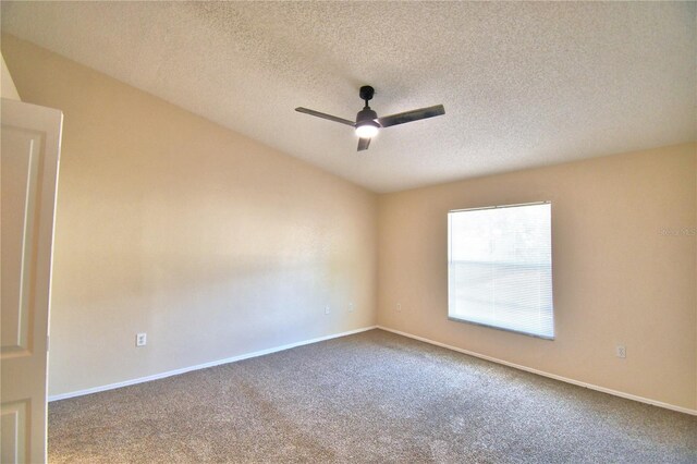 empty room featuring baseboards, a textured ceiling, ceiling fan, and dark carpet