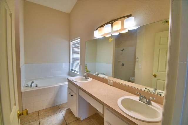 bathroom with a tile shower, tile patterned flooring, a sink, and a garden tub