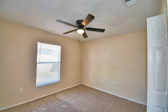 carpeted empty room with a textured ceiling, baseboards, ceiling fan, and visible vents