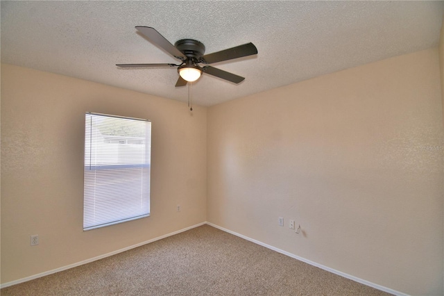 carpeted empty room with baseboards, ceiling fan, and a textured ceiling