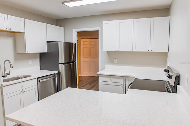 1801 3rd Ct SE, Winter Haven, FL 33880 - kitchen with a sink, appliances with stainless steel finishes, light countertops, white cabinets, and a peninsula