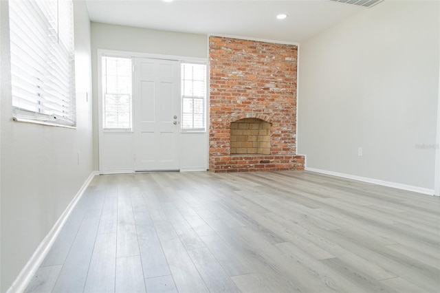 1801 3rd Ct SE, Winter Haven, FL 33880 - unfurnished living room with wood finished floors, a brick fireplace, baseboards, and recessed lighting