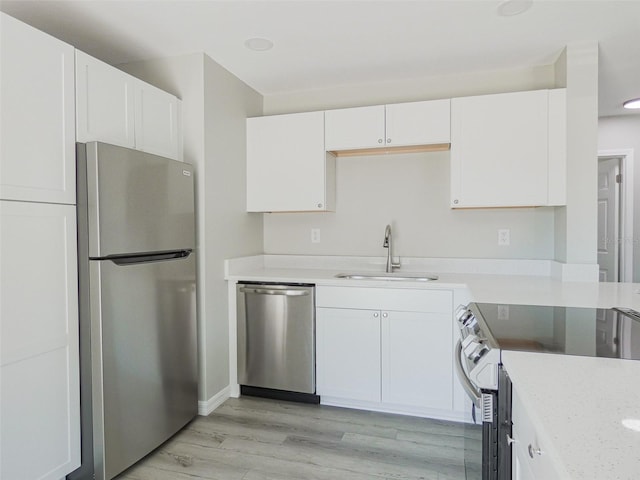 1801 3rd Ct SE, Winter Haven, FL 33880 - kitchen with stainless steel appliances, a sink, white cabinetry, and light countertops