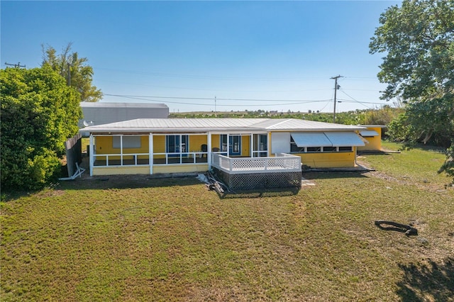 225 Wes Mann Rd, Babson Park, FL 33827 - back of house featuring metal roof, a sunroom, and a yard