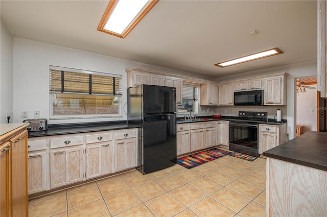 225 Wes Mann Rd, Babson Park, FL 33827 - kitchen with decorative backsplash, light brown cabinetry, dark countertops, black appliances, and light tile patterned floors