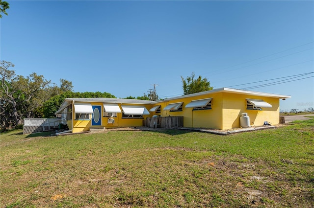 225 Wes Mann Rd, Babson Park, FL 33827 - rear view of house with concrete block siding and a lawn
