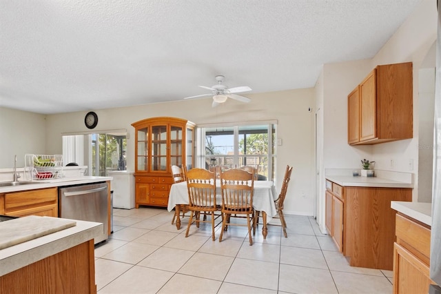 247 Cobalt Dr, Kissimmee, FL 34758 - kitchen with a textured ceiling, stainless steel dishwasher, light countertops, light tile patterned flooring, and a ceiling fan