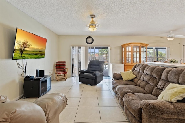 247 Cobalt Dr, Kissimmee, FL 34758 - living room featuring light tile patterned floors, a ceiling fan, a wealth of natural light, and a textured ceiling