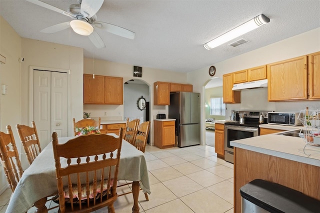 247 Cobalt Dr, Kissimmee, FL 34758 - kitchen featuring appliances with stainless steel finishes, visible vents, light countertops, arched walkways, and under cabinet range hood