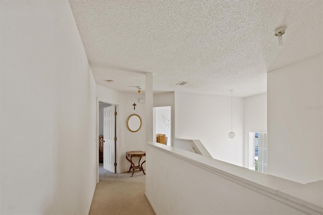 247 Cobalt Dr, Kissimmee, FL 34758 - hallway with an upstairs landing, light colored carpet, visible vents, and a textured ceiling