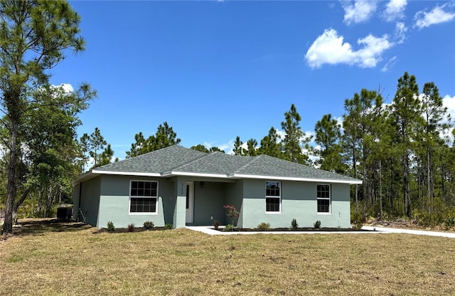 ranch-style house with a front yard, stucco siding, and roof with shingles