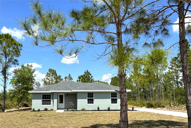 ranch-style house featuring stucco siding and a front lawn