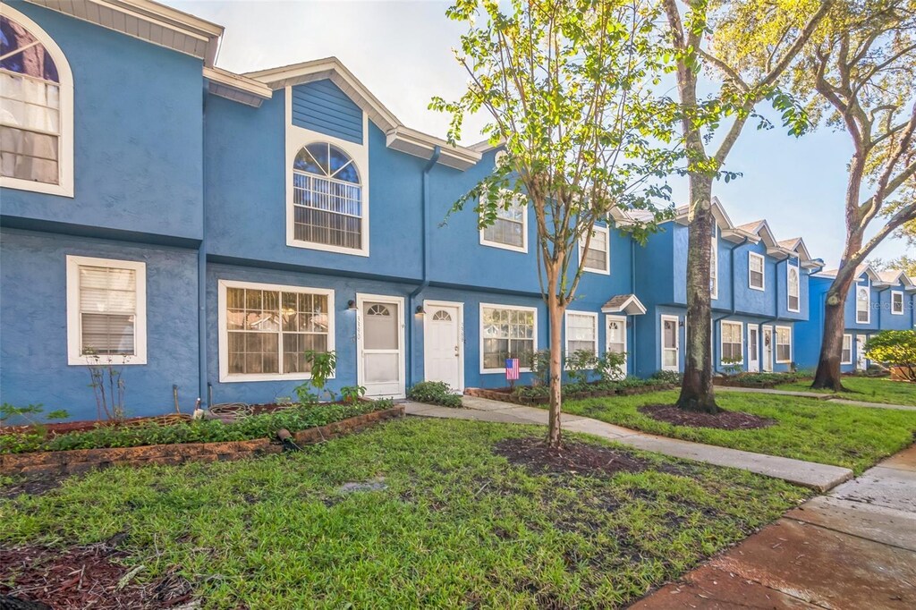 3390 Fox Hunt Dr, Palm Harbor, FL 34683 - multi unit property featuring a front lawn, a residential view, and stucco siding