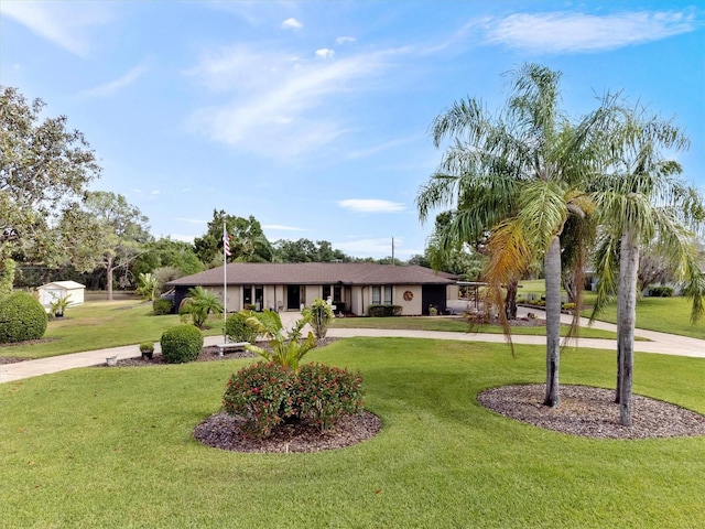 ranch-style home with a front yard, curved driveway, and stucco siding