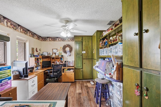 office space with a textured ceiling, visible vents, ceiling fan, and wood finished floors