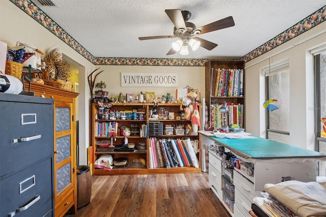 miscellaneous room featuring wood finished floors, ceiling fan, and a textured ceiling
